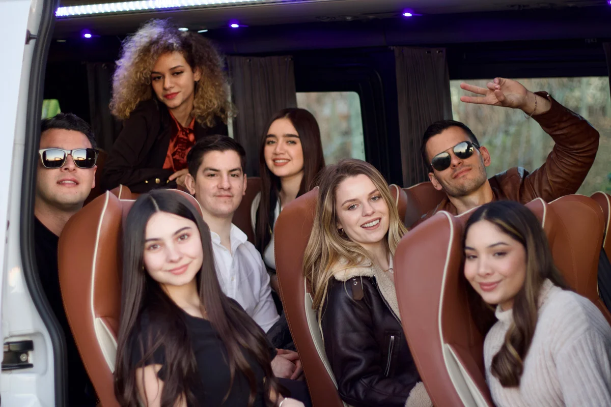 Grupo de amigos sonriendo dentro de una sprinter