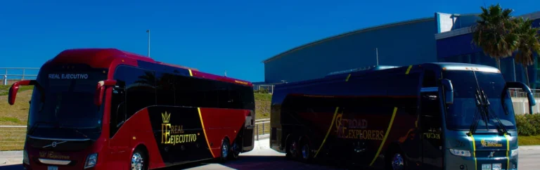 Dos autobuses ejecutivos rojo y azul de Real Ejecutivo vistos de frente
